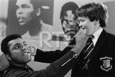 American boxer Muhammad Ali exchanges a mock punch with Philip Troy (from Presentation College, Bray, County Wicklow), in RTÉ Television's Studio 1 in July 1972
